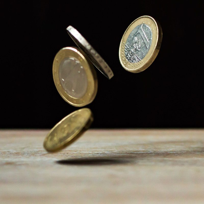 Coins on a wooden surface, representing index fund expense ratios