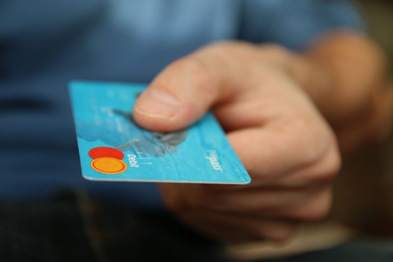 Handing over a business credit card, representing a revolving credit draw